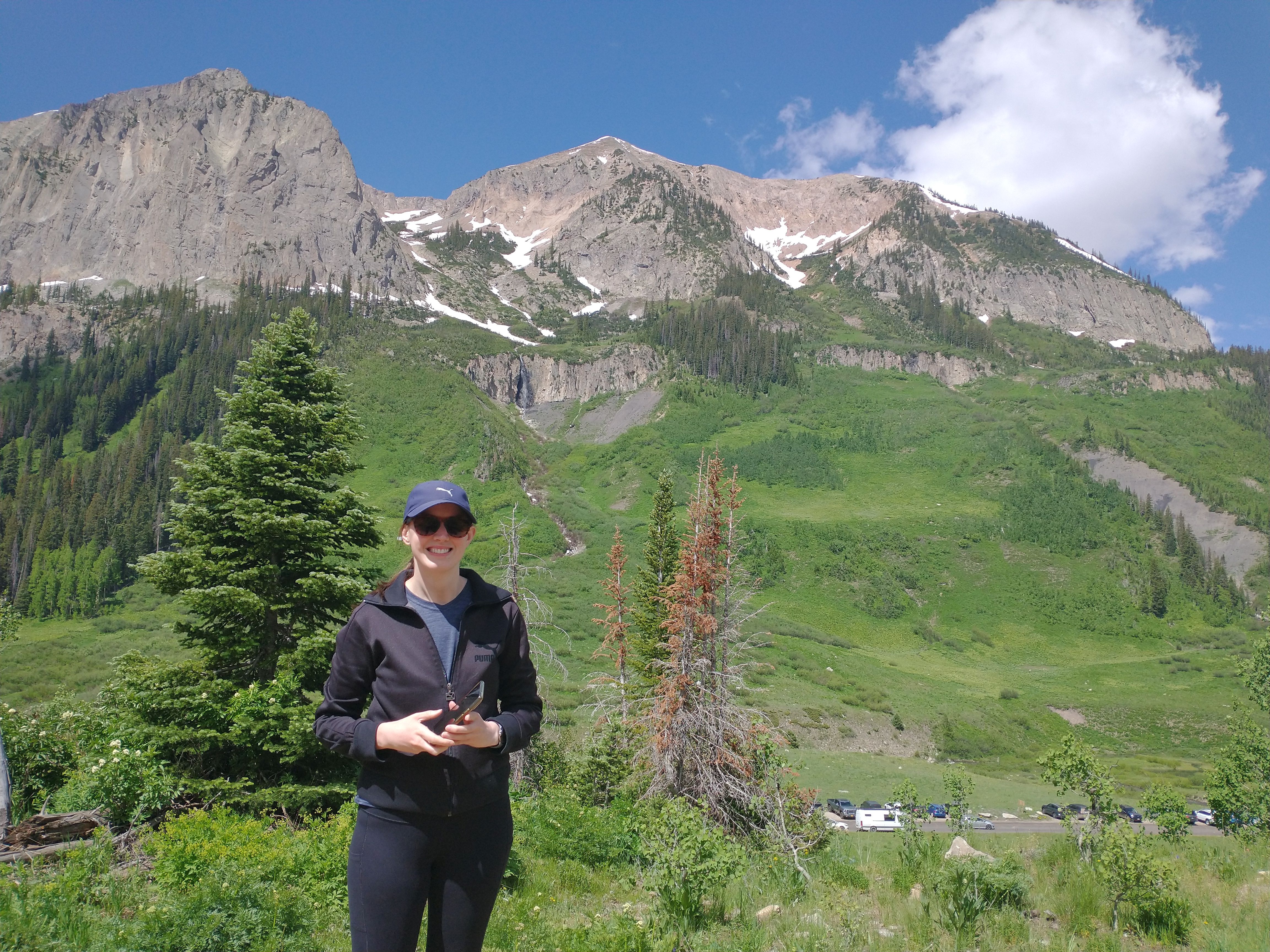 A woman in a hat in front of a big mountain
