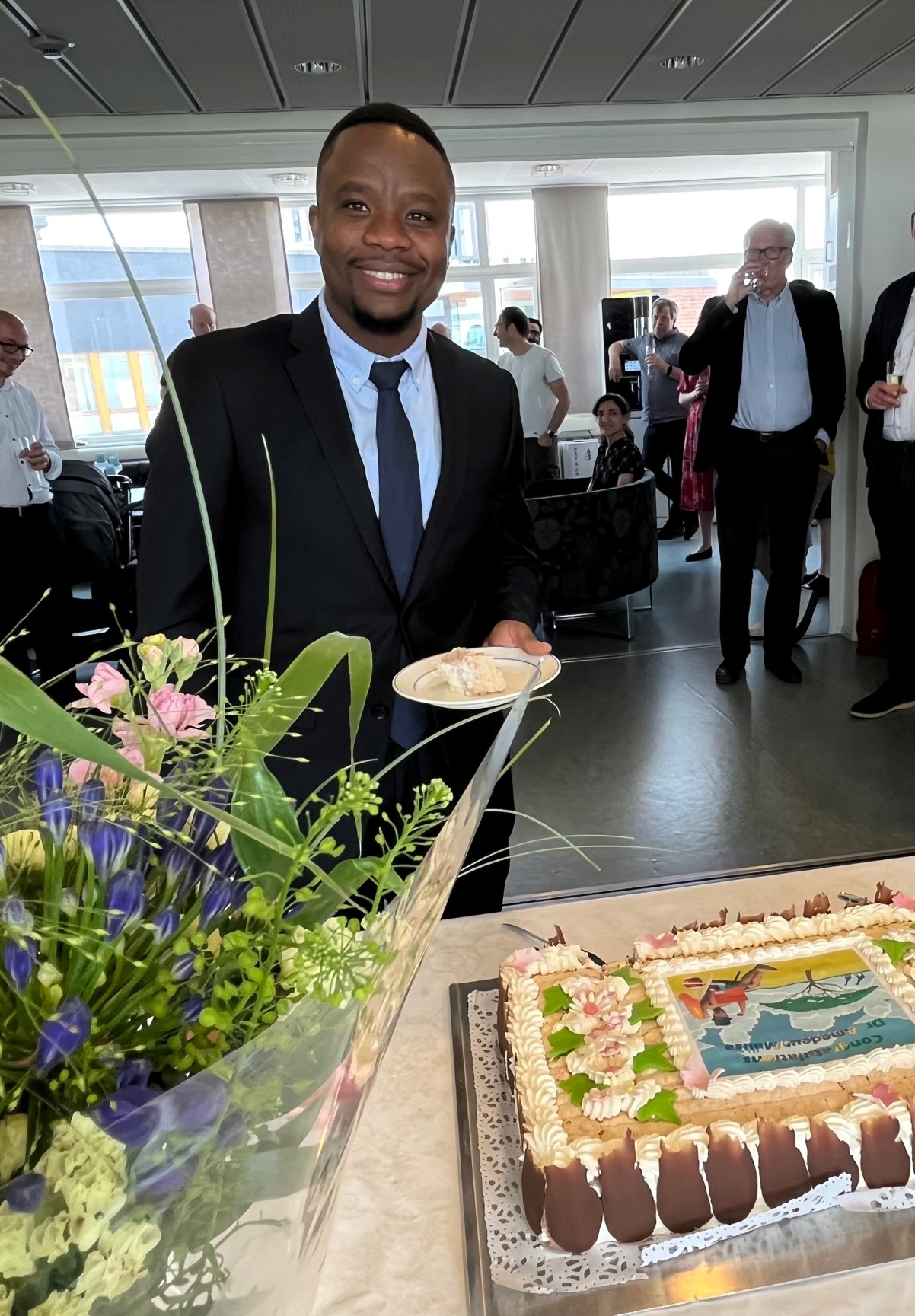 Amedeus Malisa with flowers and cake