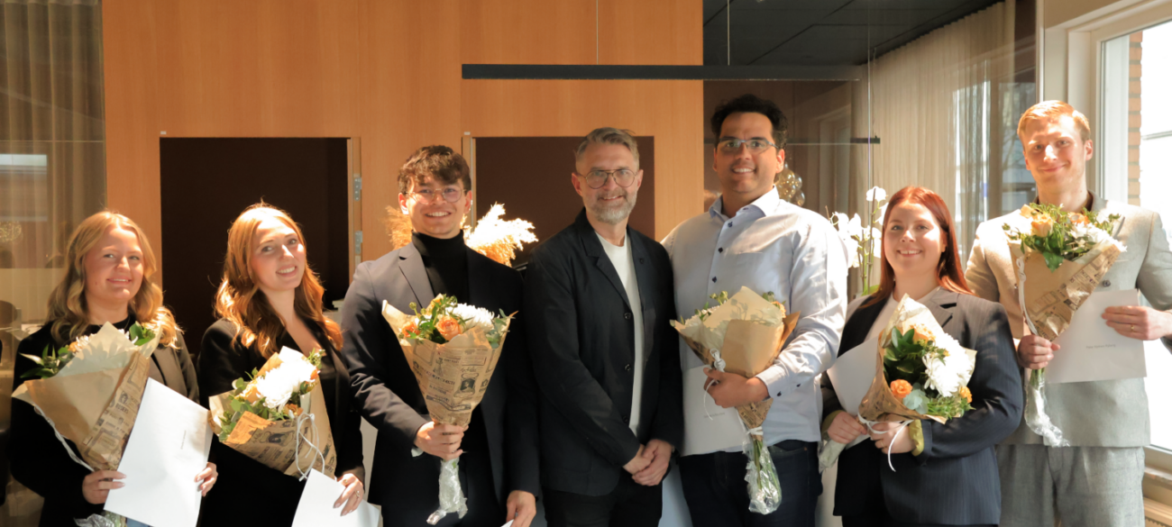 Group of 7 people looking to the camera. Each holding a bouquet of flowers after having received a financial stipend
